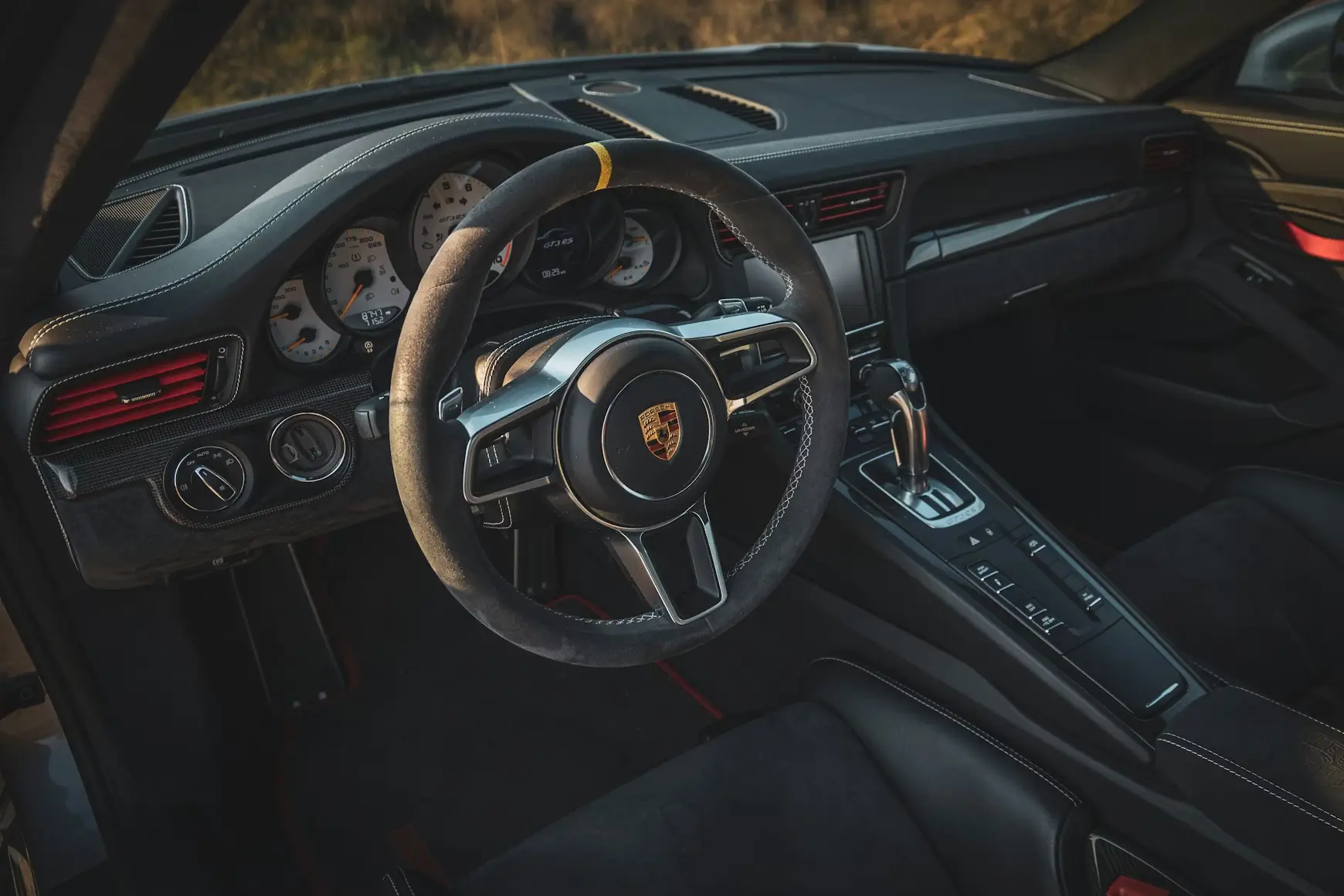 Der Innenraum eines Porsches mit Lenkrad und Armaturenbrett